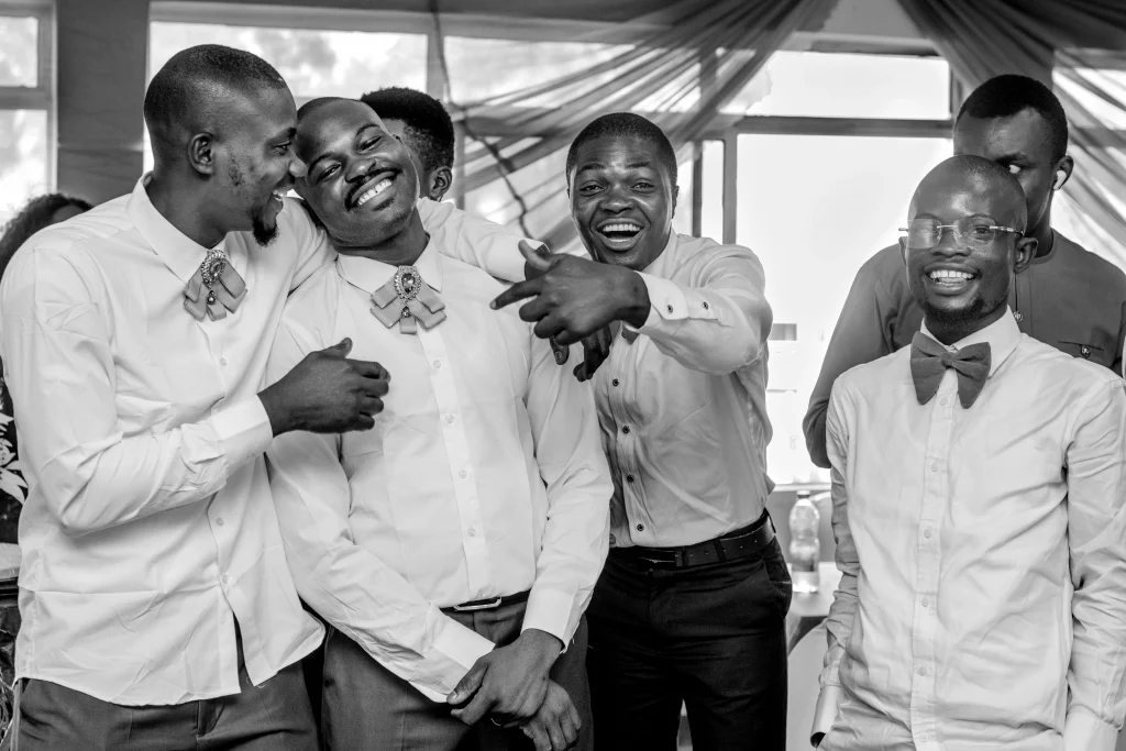 groom laughing with his groomsmen at a wedding reception by lagos wedding photographer