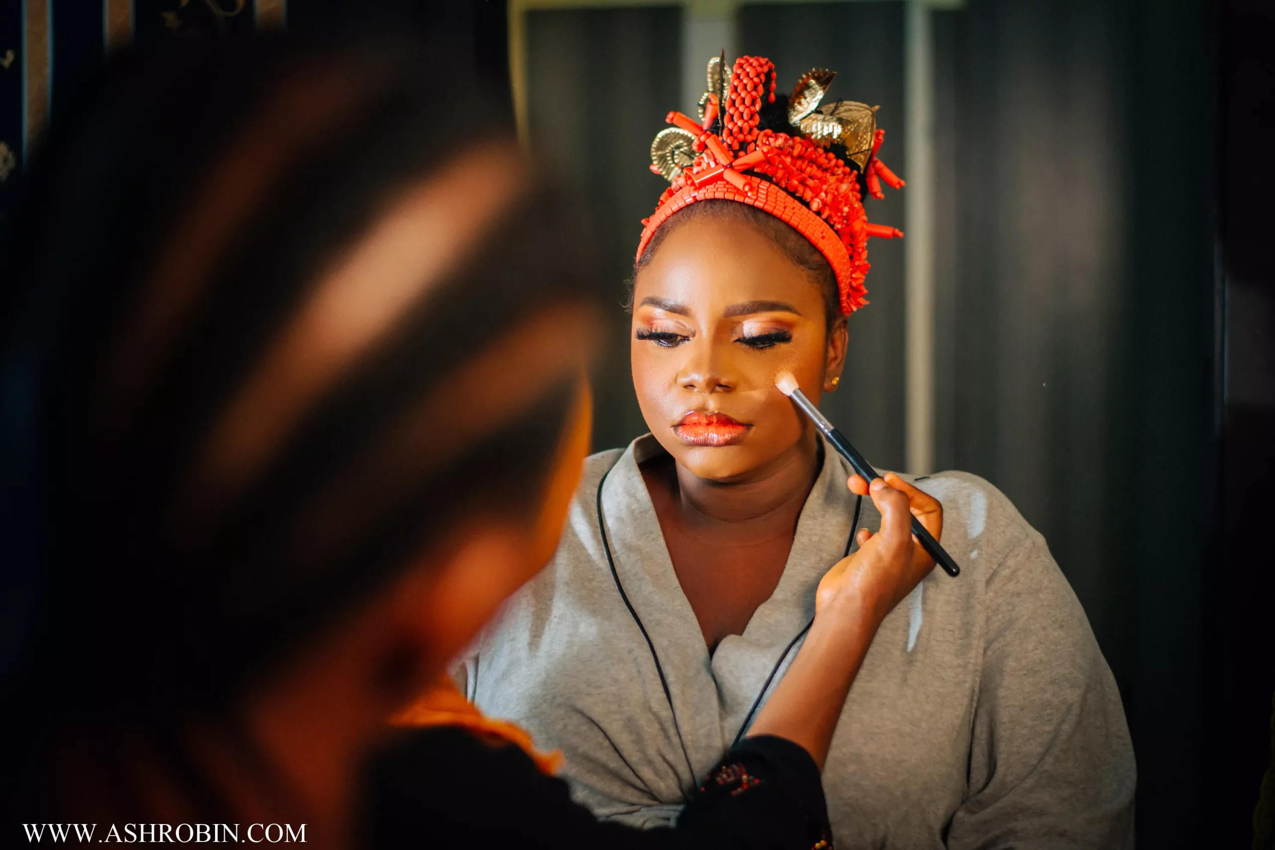 bride getting makeup done at her traditional marriage in ibadan
